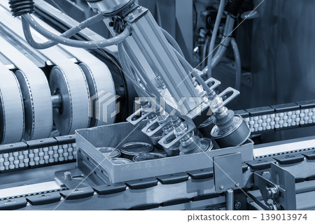 High-technology automated process of packing food cans into container boxes on a conveyor belt. High-technology automated process of packing food cans into container boxes on a conveyor belt. 139013974