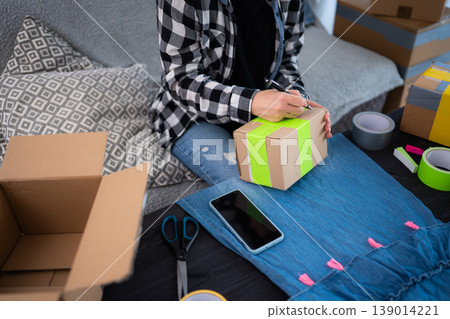 Girl Preparing Cardboard Box For Shipping 139014221