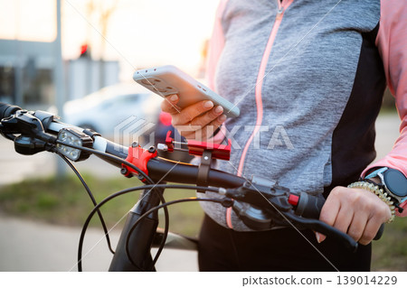 Girl Using Smartphone On A Bike Trip 139014229