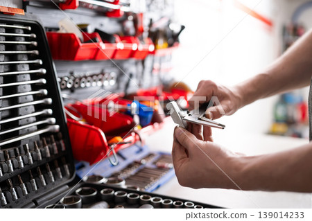 Mechanic Measuring Auto Part With Caliper 139014233