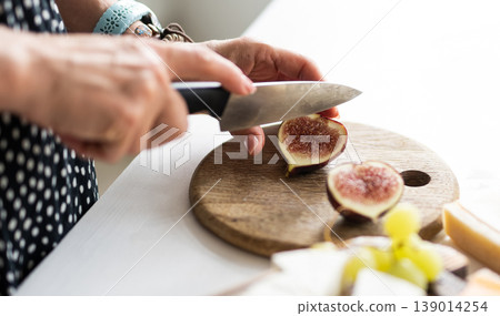 Woman Cutting Fresh Fig On A Cutting Board 139014254