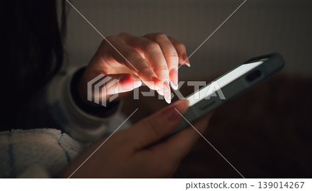 Young Girl Uses Smartphone at Home During Evening Hours 139014267