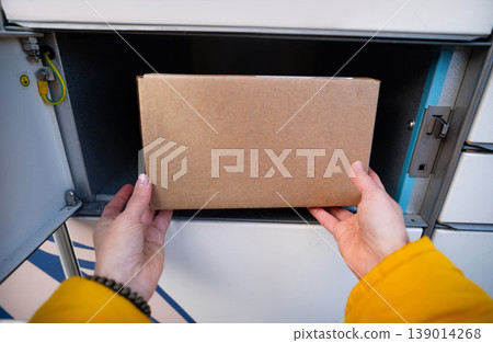 Girl's Hands Picking Up A Parcel From Parcel Automated Locker 139014268