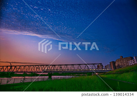 黃昏時分,一列京成列車駛過江戶川鐵道橋。 黃昏時分,一列京成列車駛過江戶川鐵道橋。 139014334