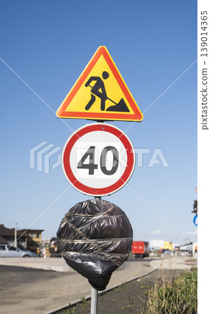 Roadwork ahead sign with speed limit 40 during road construction, temporary speed restriction for safety Roadwork ahead sign with speed limit 40 during road construction, temporary speed restriction for safety 139014365