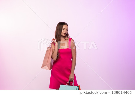 Young woman carrying shopping bags, enjoying retail therapy and sales, fashionable lifestyle consumerism Young woman carrying shopping bags, enjoying retail therapy and sales, fashionable lifestyle consumerism 139014405