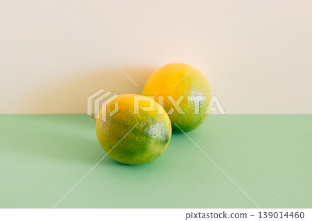 Two ripe yellow lemons on a green background. Minimal concept. Two ripe yellow lemons on a green background. Minimal concept. 139014460
