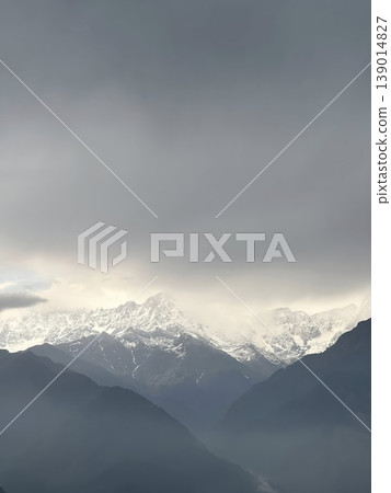 Dramatic Landscape of Snow-Capped Mountain Peaks under a Moody Overcast Sky Dramatic Landscape of Snow-Capped Mountain Peaks under a Moody Overcast Sky 139014827