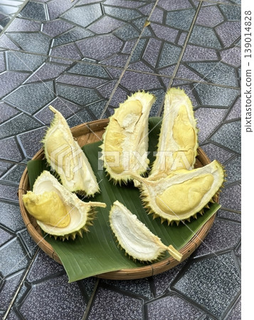 Fresh Cut Durian Fruit Pieces on Banana Leaf in a Traditional Bamboo Basket Fresh Cut Durian Fruit Pieces on Banana Leaf in a Traditional Bamboo Basket 139014828