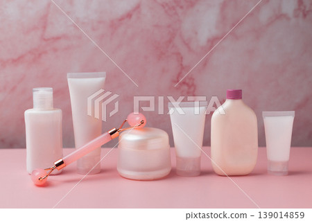Skincare beauty products set with facial roller, cream jar, serum dropper and cosmetic bottles on pink background, beauty routine concept Skincare beauty products set with facial roller, cream jar, serum dropper and cosmetic bottles on pink background, beauty routine concept 139014859