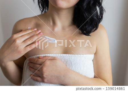 Woman applying moisturizing skincare cream on shoulder after shower, body care and beauty routine concept Woman applying moisturizing skincare cream on shoulder after shower, body care and beauty routine concept 139014861