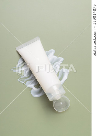 Minimal skincare cosmetic tube with moisturizing cream texture on soft green background, beauty product concept Minimal skincare cosmetic tube with moisturizing cream texture on soft green background, beauty product concept 139014879