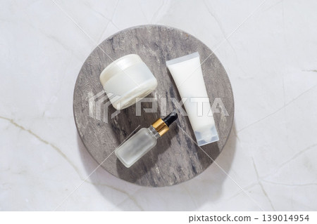 Minimal skincare set with cream jar, cosmetic tube and serum dropper on marble tray, beauty routine concept Minimal skincare set with cream jar, cosmetic tube and serum dropper on marble tray, beauty routine concept 139014954