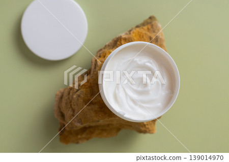 Open cosmetic cream jar with white moisturizing face cream on natural stone background, skincare product texture, minimal beauty concept Open cosmetic cream jar with white moisturizing face cream on natural stone background, skincare product texture, minimal beauty concept 139014970
