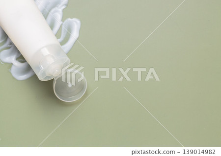 Minimal skincare cosmetic tube with moisturizing cream texture on soft green background, beauty product concept Minimal skincare cosmetic tube with moisturizing cream texture on soft green background, beauty product concept 139014982