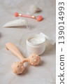 Skincare beauty routine with cosmetic tubes, cream jar and facial massage rollers on marble background, wellness concept 139014993
