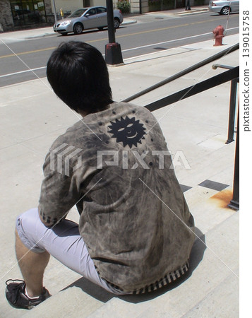 A Japanese man, exhausted from his trip to America, sits down on a sidewalk from behind – an image representing overseas travel and fatigue. A Japanese man, exhausted from his trip to America, sits down on a sidewalk from behind – an image representing overseas travel and fatigue. 139015758