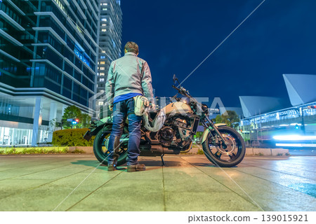 A male rider standing with his motorcycle in Yokohama Minato Mirai. A male rider standing with his motorcycle in Yokohama Minato Mirai. 139015921