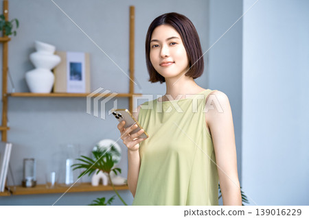 A modern lifestyle of a smiling Asian woman using a smartphone. A modern lifestyle of a smiling Asian woman using a smartphone. 139016229
