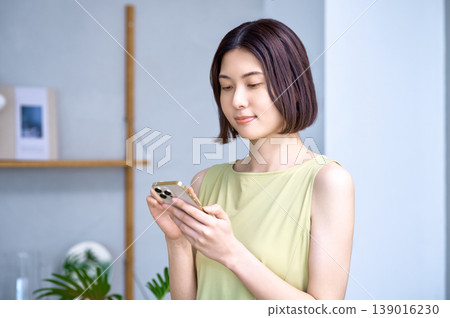 一位年輕的日本女性在家中使用智慧型手機 139016230