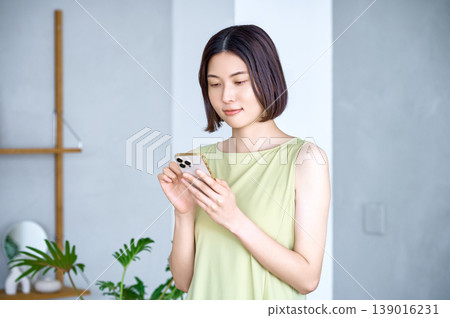 一位年輕女性使用智慧型手機的現代生活方式 一位年輕女性使用智慧型手機的現代生活方式 139016231