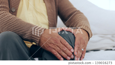 Hands, knee pain and senior man on a sofa with arthritis, fibromyalgia or osteoporosis closeup. Legs, problem and zoom of elderly person with massage for relief from inflammation, injury or joint Hands, knee pain and senior man on a sofa with arthritis, fibromyalgia or osteoporosis closeup. Legs, problem and zoom of elderly person with massage for relief from inflammation, injury or joint 139016273