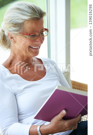 Senior woman, home and book with smile for reading, relax and living room with ideas for story, knowledge or glasses. Happy elderly lady, person and vision in lounge in retirement with novel in house 139016298