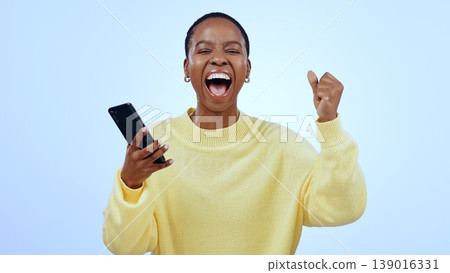 Woman, phone and wow for happy news, social media competition or giveaway success on a blue background. Portrait of African person with surprise, excited and yes for sale or bonus on mobile in studio Woman, phone and wow for happy news, social media competition or giveaway success on a blue background. Portrait of African person with surprise, excited and yes for sale or bonus on mobile in studio 139016331