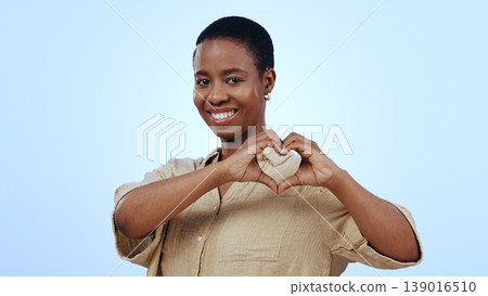 Heart, hands and portrait of black woman in studio for kindness, care and charity donation on blue background. Happy model show sign of love, hope and thank you for support, emoji and review of peace Heart, hands and portrait of black woman in studio for kindness, care and charity donation on blue background. Happy model show sign of love, hope and thank you for support, emoji and review of peace 139016510