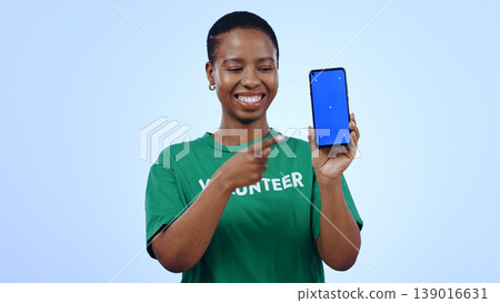 Woman, volunteer and phone green screen, presentation mockup and support, join us or marketing in studio. Happy African person pointing to mobile, information and NGO volunteering on blue background 139016631