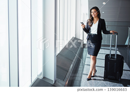 Business woman, phone and bag by airport window with smile, thinking and vision for international travel. Entrepreneur, suitcase and smartphone with flight schedule for global immigration in London Business woman, phone and bag by airport window with smile, thinking and vision for international travel. Entrepreneur, suitcase and smartphone with flight schedule for global immigration in London 139016683