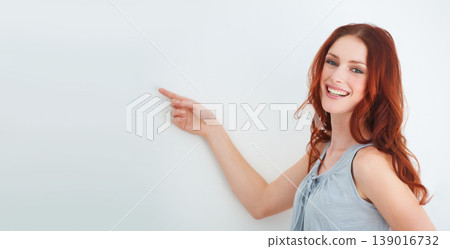 Portrait, happy woman and smile for pointing in studio for presentation mockup for on white background in Ireland. Female model, expression or excitement on face for announcement, offer or promotion Portrait, happy woman and smile for pointing in studio for presentation mockup for on white background in Ireland. Female model, expression or excitement on face for announcement, offer or promotion 139016732