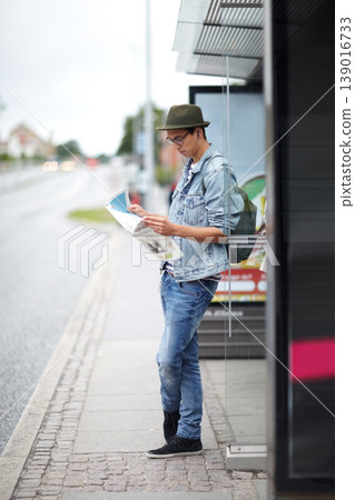 Man, journey and bus stop with map, travel and adventure by commute, transportation and planning for trip. Male person, information and guide for direction, navigation and vacation or earphones Man, journey and bus stop with map, travel and adventure by commute, transportation and planning for trip. Male person, information and guide for direction, navigation and vacation or earphones 139016733