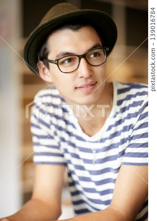 Fashion, thinking and a young hipster man in a glasses for vision or eyesight on a blurred background. Style idea, eyewear and a confident person in a hat as a casual clothing outfit accessory Fashion, thinking and a young hipster man in a glasses for vision or eyesight on a blurred background. Style idea, eyewear and a confident person in a hat as a casual clothing outfit accessory 139016784