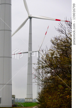 wind turbines in field rotate their blades to generate energy. windmill on spacious green field. 139016799