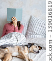 woman in bed writes in personal diary, writes down emotions, writes down wish list. mental health. 139016819