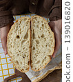 person is holding white bread in hands. homemade sourdough bread with crispy crust.  139016820