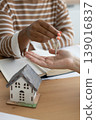 Close-up of happy woman realtor or property owner handing over key to house.  139016837