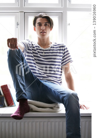 Portrait, window and an asian man in the bedroom of his home to relax in the morning of a weekend in summer. Fashion, style and a confident young model chilling in his apartment for time off Portrait, window and an asian man in the bedroom of his home to relax in the morning of a weekend in summer. Fashion, style and a confident young model chilling in his apartment for time off 139016960