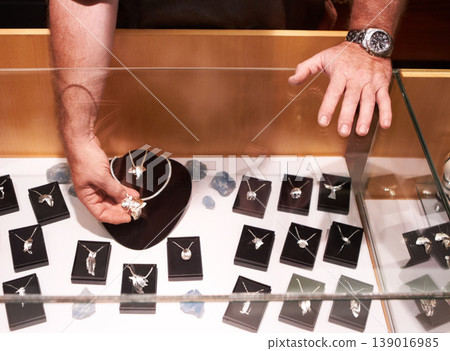 Silver, jewelry and hands with display for shopping, customer and seller in retail. Africa symbol, design and person showcase necklace with diamond in creative store, window or artisan jewellery 139016985