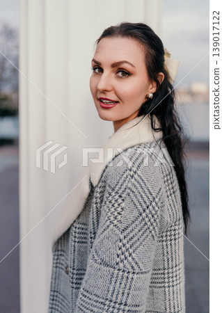 Woman Coat Portrait young lady in grey plaid jacket with white faux fur collar looking over her shoulder outdoors 139017122