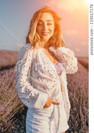 Woman lavender sunset beautiful young woman smiles while standing in a blooming purple lavender field during sunset golden hour 139017178