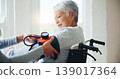 Woman, doctor and senior in wheelchair for blood pressure, monitoring or elderly care at old age home. Nurse or medical caregiver checking BPM of mature patient or person with a disability at house 139017364
