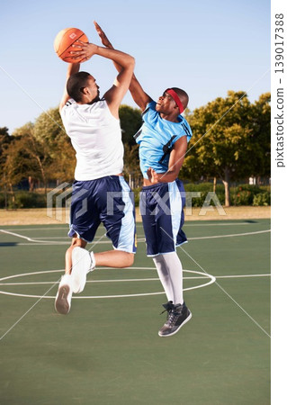 Basketball, training and men jump on court in game with ball, workout and outdoor exercise in sports. Fitness, competition and athlete shooting for a goal, challenge or stretching to score in match 139017388