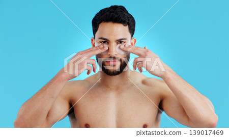 Skincare, portrait and man with eye patches for anti ageing treatment isolated on blue background. Care, skin and face of model with collagen mask on eyes, dermatology and luxury spa facial in studio 139017469