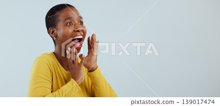 Happy black woman, face and screaming in surprise, winning prize or celebration against a studio background. Excited African female person in wow, shock or bonus promotion on sale discount or deal 139017474