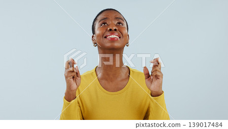 Hope, wish and black woman in studio with fingers crossed for opportunity, deal or good news prayer. Praying hands, thinking and person with winning dream, confidence and faith on white background. Hope, wish and black woman in studio with fingers crossed for opportunity, deal or good news prayer. Praying hands, thinking and person with winning dream, confidence and faith on white background. 139017484