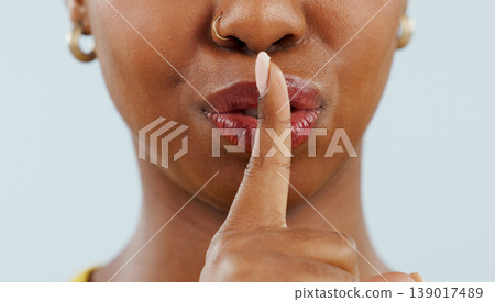 Black woman, mouth and lips in secret for gossip, privacy or confidential information against a studio background. Closeup of African female person with finger or emoji in silence, quiet or whisper Black woman, mouth and lips in secret for gossip, privacy or confidential information against a studio background. Closeup of African female person with finger or emoji in silence, quiet or whisper 139017489