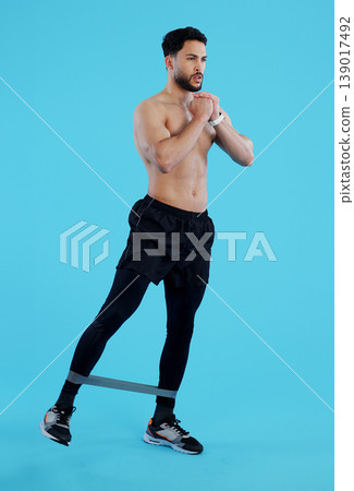 Man, legs and resistance band in workout, training or fitness against a blue studio background. Male person, athlete or serious model with straps for cardio exercise, endurance or stamina on mockup Man, legs and resistance band in workout, training or fitness against a blue studio background. Male person, athlete or serious model with straps for cardio exercise, endurance or stamina on mockup 139017492