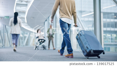 Closeup, walking and man with a suitcase, back and airport to travel, vacation or holiday in airline hallway. Luggage, legs and person on flight terminal, immigration journey or international trip 139017525